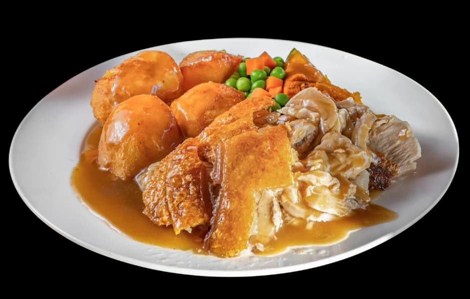 Roast pork meal with crackling, roast potatoes and pumpkin in gravy